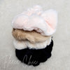 Fluffy scrunchies in different colors are stacked on top of one another - Fleece Chic