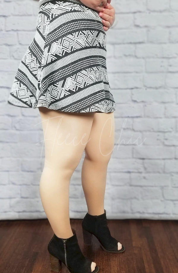Fleece lined tights in beige with fuzzy lining are paired with a geometric patterned skirt and black booties - Fleece Chic