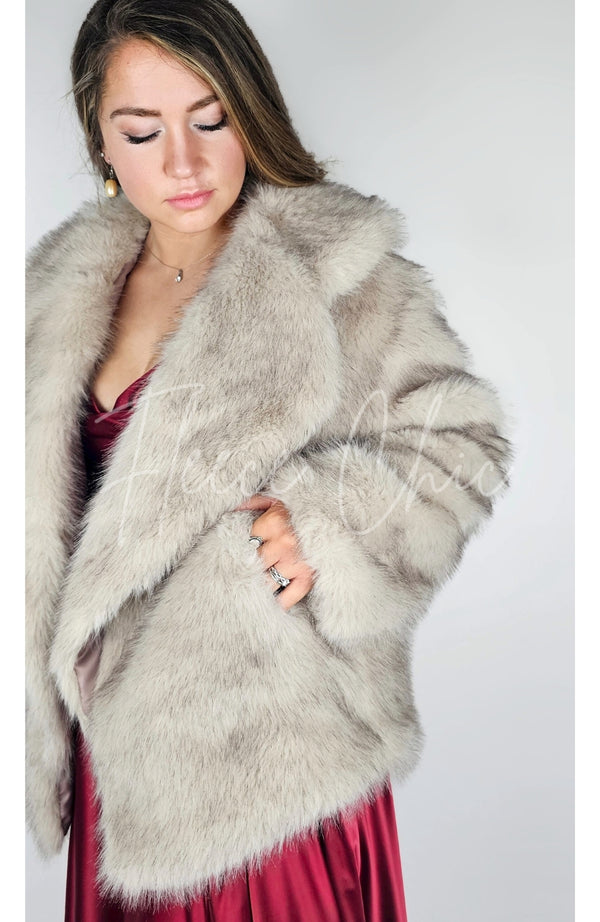 A woman wears a fox fur coat and tucks her hand into one of its pockets - Fleece Chic