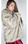 A woman poses in a fox fur coat and red silk dress - Fleece Chic