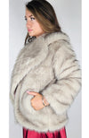 A woman wears a fox fur coat and tucks her hand into one of its pockets - Fleece Chic