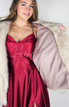 Fox fur coat by Fleece Chic is worn by a woman in a red silk dress who shows off its inside.