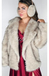 A woman wears a fox fur coat with rabbit earmuffs by Fleece Chic.