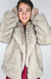 A woman wears a fox fur coat with rabbit earmuffs by Fleece Chic.