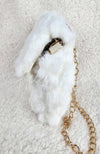 A close-up detailed image of a beautiful fur purse that is white with a golden chain by Fleece Chic shown from its side profile.