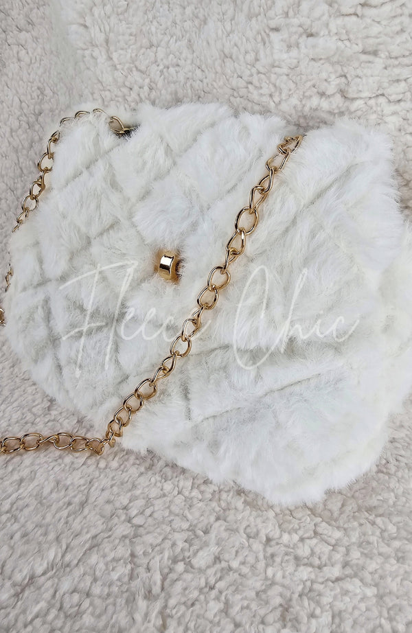 A close-up detailed image of a beautiful fur purse that is white with a golden chain by Fleece Chic