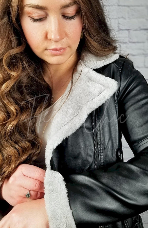 A Vegan Leather Jacket has its plush fleece collar and sleeve displayed for the camera - Fleece Chic