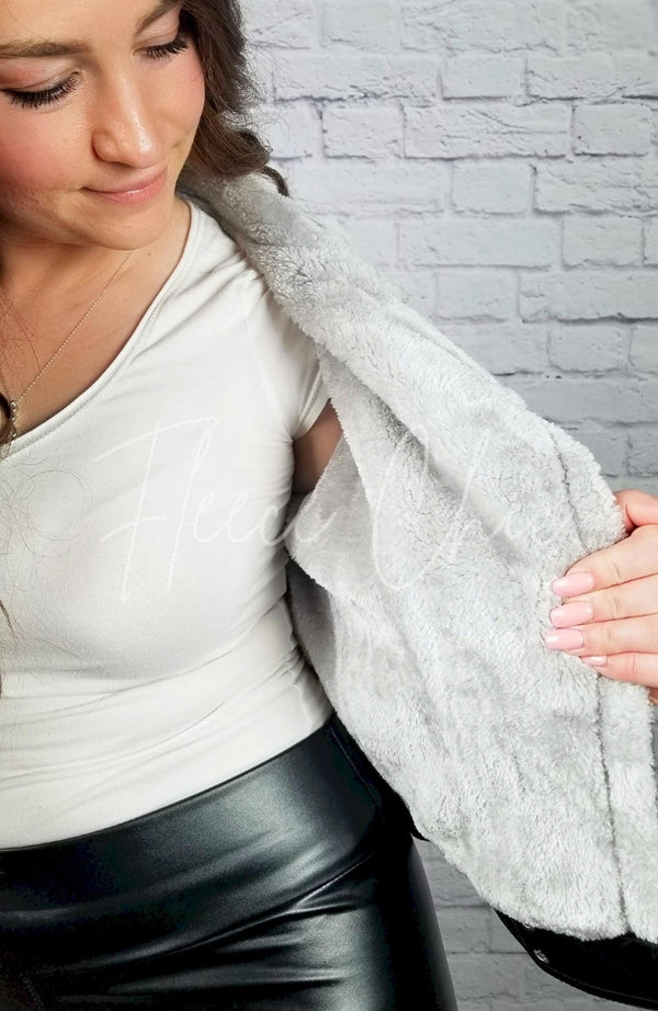 A Vegan Leather Jacket has its plush fleece lining displayed for the camera - Fleece Chic