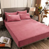 A set of rose colored fitted fleece sheets and pillowcases on a bed in a cozy room setting - Fleece Chic