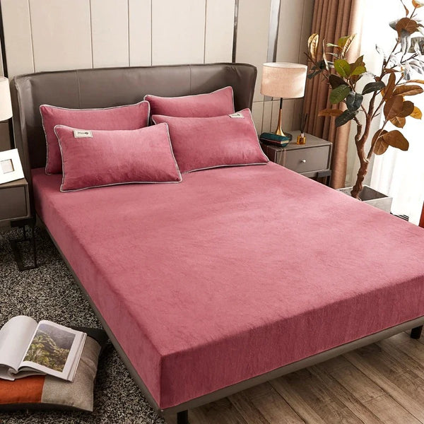 A set of rose colored fitted fleece sheets and pillowcases on a bed in a cozy room setting - Fleece Chic
