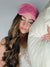 A woman sleeps on a pillow while wearing a pink Faux Fur Sleep Mask by Fleece Chic.
