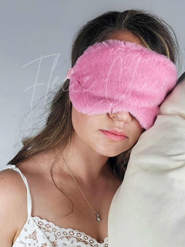 A woman sleeps with Fleece Chic's Sweet Dreams Faux Fur Sleep Mask on.