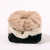 Fluffy Scrunchies by Fleece Chic are stacked on top of eachother.