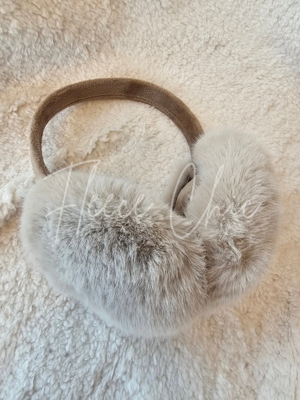 Light brown fur earmuffs are shown on a sherpa background - Fleece Chic