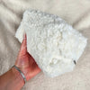 A woman holds a white sherpa bag that is rectangular and has a flower lining - Fleece Chic