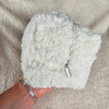 A woman holds a white sherpa bag that is rectangular and has a flower lining - Fleece Chic