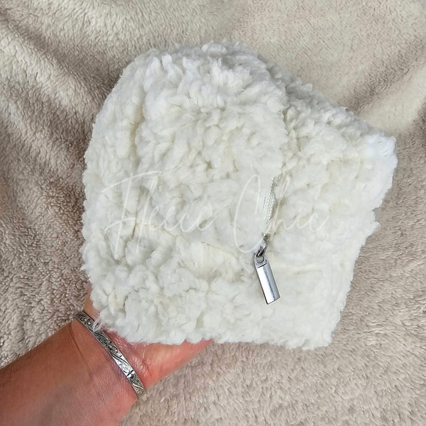 A woman holds a white sherpa bag that is rectangular and has a flower lining - Fleece Chic