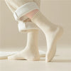 A woman wears a pair of Oatmeal-colored thick socks by Fleece Chic