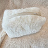 A fur bag that is white and is made with faux material is displayed zipped closed - Fleece Chic