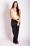 A woman wears a beige thermal tank top with lace paired with black knit pants by Fleece Chic.