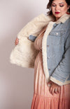 A plus size model shows off the interior of Fleece Chic's reversible fur lined trucker jacket.