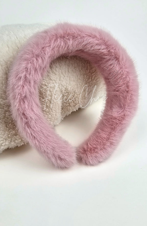 A closeup of a fur headband that is dusty pink by Fleece Chic.