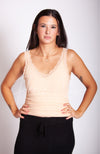 A woman wears a beige thermal tank top with lace paired with black knit pants by Fleece Chic.