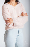 A woman crosses her arms while wearing a fluffy sweater by Fleece Chic.