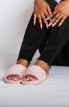 A woman in black winter leggings wears pink fuzzy slides by Fleece Chic.