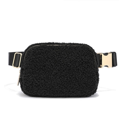 Black shearling hip bag with gold buckle on a white background by Fleece Chic. 