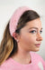 A woman wears a pink fur headband by Fleece Chic.