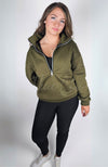 A woman wears a black pair of cozy leggings with a plush lining and the green top of the Effortlessly Chic Tracksuit by Fleece Chic.