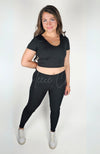 A woman wears a black pair of cozy leggings by Fleece Chic.