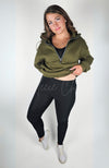 A woman wears a black pair of cozy leggings with a plush lining and the green top of the Effortlessly Chic Tracksuit by Fleece Chic.