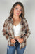 A woman wears a Lined Flannel Shirt Jacket paired with a white crop top and jeans - Fleece Chic