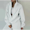 A white tracksuit with matching sweatshirt and sweatpants are worn by a woman who is posing for the camera - Fleece Chic