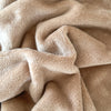A cozy blanket that is tan has a close up to show its detail - Fleece Chic