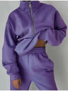 Purple fleece loungewear with matching sweatshirt and sweatpants are worn by a woman who is holding up the top to expose her midriff - Fleece Chic