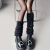 A black fluffy leg warmer is worn with black tights and shiny shoes - Fleece Chic