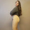 Nude tights in beige color that are opaque with fleece lining have their side profile modeled by a woman in a gray sweater with long brown hair - Fleece Chic