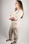 A model poses in a beige sweat set while facing the left and showing her profile - Fleece Chic