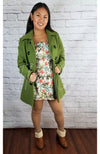 Plush tights that are light brown are worn by an Asian woman who is posing in a colorful dress, green pea coat, and fluffy winter boots - Fleece Chic