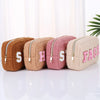 Travel pouches for makeup or toiletries with chenille patches are lined up to display their different colors - Fleece Chic