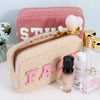 Travel pouches for makeup or toiletries with chenille patches are displayed with cosmetics - Fleece Chic