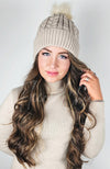 A woman wears a fleece hat with a cute pom pom on it by Fleece Chic.