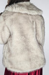 A woman wears a fox coat and displays the back for the camera - Fleece Chic