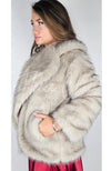 A woman wears a fox coat and tucks her hand into one of its pockets - Fleece Chic