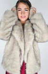 A woman wears a fox coat with rabbit earmuffs by Fleece Chic