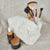 A Sherpa bag with a flower lining is pictured with various makeup brushes and face ointments - Fleece Chic