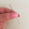 A snag repair needle is held up to show features like burrs on butt end, silver color, and sharp point - Fleece Chic